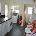 Utility room with washer/ dryer, sink, washing machine and baby chair