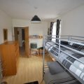 Bunk bed in a bedroom with a small TV in the corner
