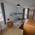 Bunk bed in a bedroom with a small TV in the corner